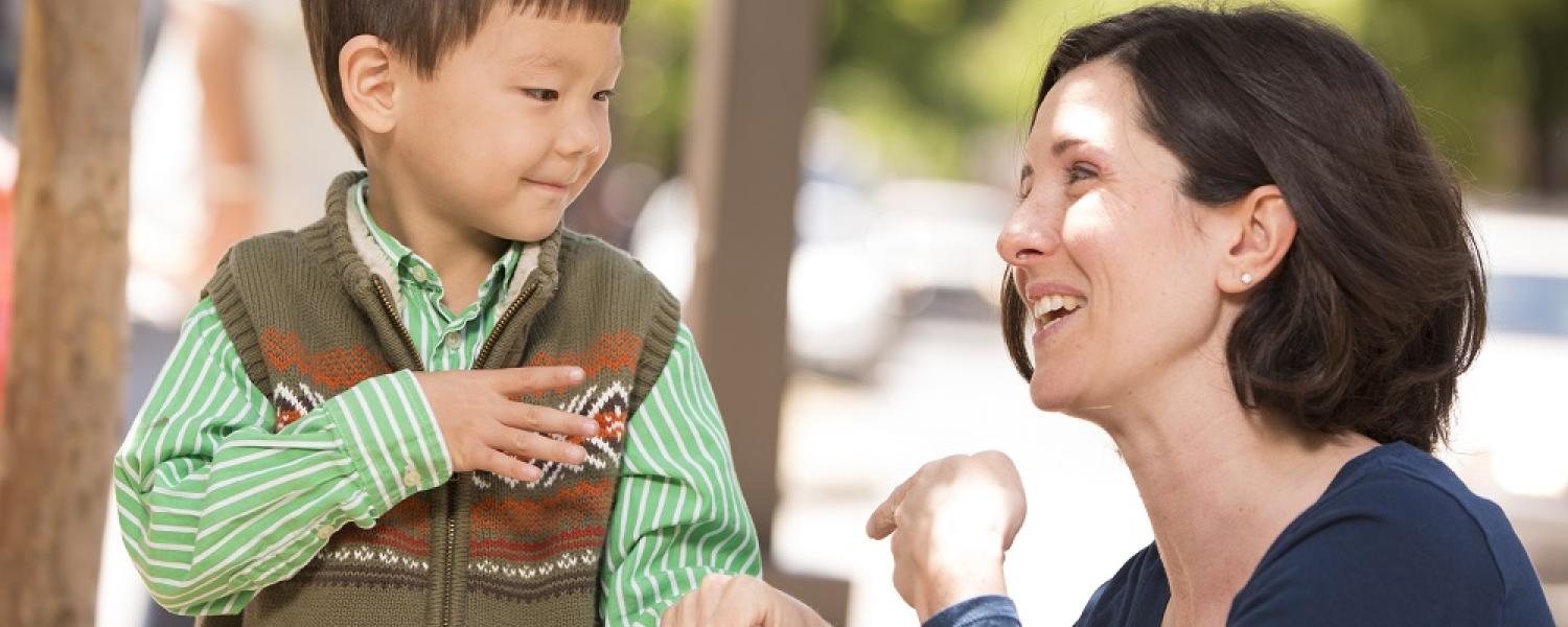 Educator and a child communicating using sign language