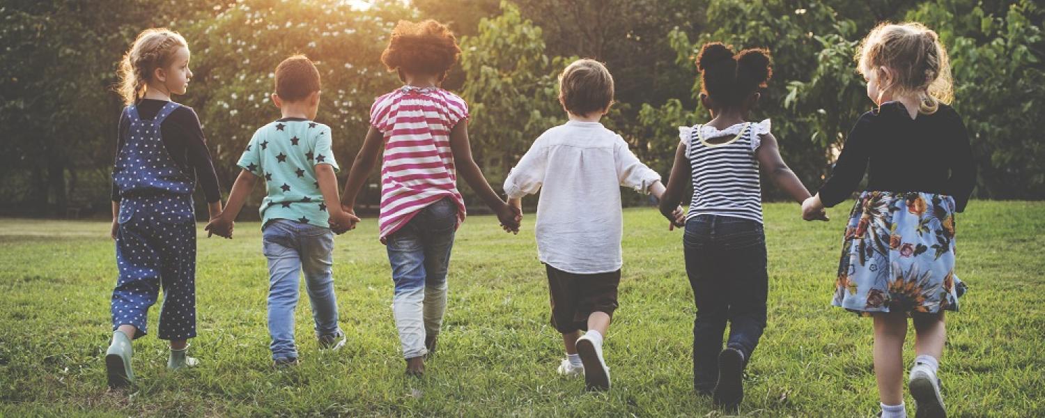 Children holding hands together walking in the park