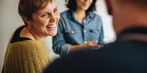 three educators smiling in conversation