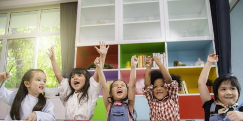 Young children with arms up in the air in celebration