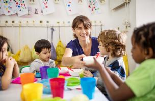 Teacher and children at meal time